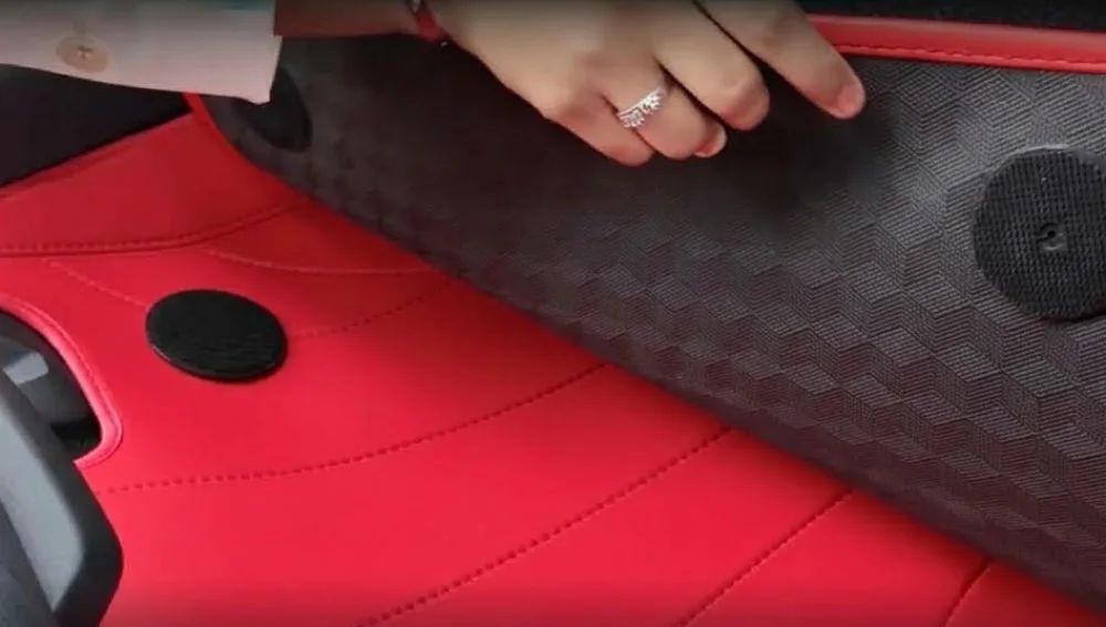 A hand lifting the black Tex-Mesh top layer off a red EZYMAT base layer